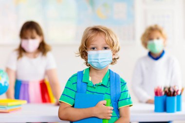 Corona virüsü ve grip salgını sırasında yüz maskesi takan okul çocuğu. Erkek ve kız covid-19 karantina ve tecritten sonra okula geri dönüyorlar. Koronavirüsü önlemek için maskeli bir grup çocuk.. 