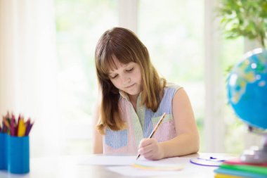 Gökkuşağı çizen çocuk. Ellerinde boya var. Evden uzaktan öğrenme ve online okul sanat ödevi. Çocuklar için sanat ve el sanatları. Küçük kız parlak bir resim çiziyor. Yaratıcı çocuk oynuyor ve çalışıyor..