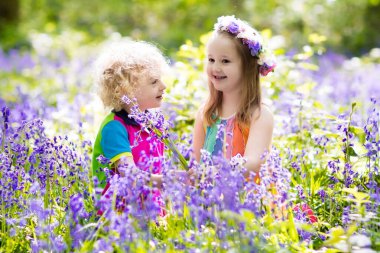 Bluebell çiçek, Bahçe aletleri ve el arabası çocuklarla. Erkek ve kız Bahçe. Çocuk bluebells, iş, bitki ve su blue Bell'de Çiçeklik açık oyun. Yaz ormandaki aile eğlence.