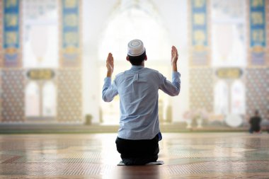 Ramazan Kareem selamı. Camide tespih taşıyan bir adam. Müslüman erkek namaz kılıyor. Kuran okuyup namaz kılarlar. Oruç sona erdi. Hari Raya günü. Bayram kutlamaları var. Kutsal oruç gününün başlangıcı. 