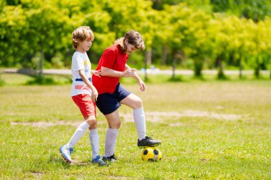 Çocuk futbol oynuyor. Çocuklar dışarıda futbol oynarlar. Küçük çocuk yaz parkında topa vuruyor. Küçük çocuklar için sağlıklı bir aktivite. Okul spor kulübü takımı. Futbol Küçükler Ligi.