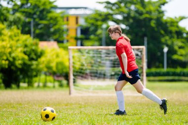 Çocuk futbol oynuyor. Çocuklar dışarıda futbol oynarlar. Yaz parkında top oynayan genç kız. Küçük çocuklar için sağlıklı bir aktivite. Okul spor kulübü takımı. Futbol Küçükler Ligi.