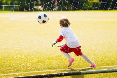 Çocuk futbol oynuyor. Çocuklar dışarıda futbol oynarlar. Küçük çocuk yaz parkında topa vuruyor. Küçük çocuklar için sağlıklı bir aktivite. Okul spor kulübü takımı. Futbol Küçükler Ligi.