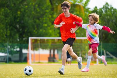 Çocuk futbol oynuyor. Çocuklar dışarıda futbol oynarlar. Küçük çocuk yaz parkında topa vuruyor. Küçük çocuklar için sağlıklı bir aktivite. Okul spor kulübü takımı. Futbol Küçükler Ligi.