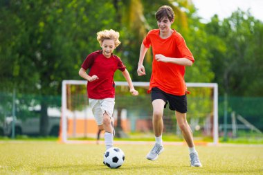Çocuk futbol oynuyor. Çocuklar dışarıda futbol oynarlar. Küçük çocuk yaz parkında topa vuruyor. Küçük çocuklar için sağlıklı bir aktivite. Okul spor kulübü takımı. Futbol Küçükler Ligi.