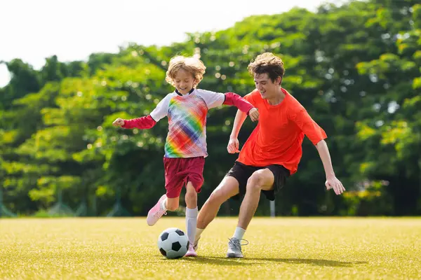 Çocuk futbol oynuyor. Çocuklar dışarıda futbol oynarlar. Küçük çocuk yaz parkında topa vuruyor. Küçük çocuklar için sağlıklı bir aktivite. Okul spor kulübü takımı. Futbol Küçükler Ligi.