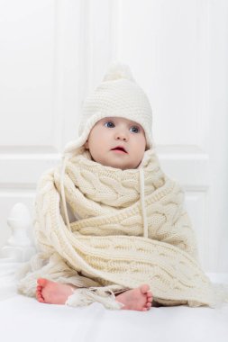 Beyaz güneşli yatak odasında sevimli bir bebek. Yeni doğmuş çocuk yatakta dinleniyor. Küçük çocuklar için çocuk odası. Çocuklar için tekstil ve yatak. Aile sabahı evde. Oyuncak ayıyla karnını doyururken doğan yeni çocuk..