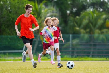 Çocuk futbol oynuyor. Çocuklar dışarıda futbol oynarlar. Küçük çocuk yaz parkında topa vuruyor. Küçük çocuklar için sağlıklı bir aktivite. Okul spor kulübü takımı. Futbol Küçükler Ligi.