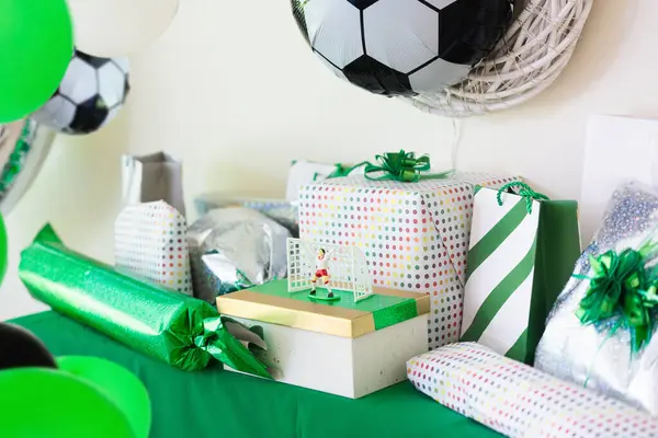 stock image Kids birthday. Football theme child party. Little boy holding gift box and balloon on his birthday morning. Soccer and sports decoration. Children open present.