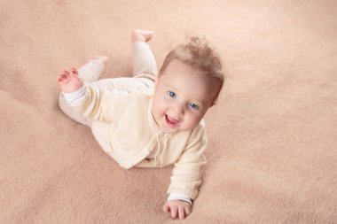 Beyaz güneşli yatak odasında sevimli bir bebek. Yeni doğmuş çocuk yatakta dinleniyor. Küçük çocuklar için çocuk odası. Çocuklar için tekstil ve yatak. Aile sabahı evde. Oyuncak ayıyla karnını doyururken doğan yeni çocuk..