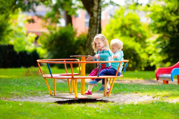 Çocuklar doğayı keşfeder. Çocuklar güneşli parkta oynarlar. Çocuk güzel bir yaz parkında oyun parkında. Aktif aile için açık hava eğlencesi. Çocuk sallanıyor ve kayıyor..