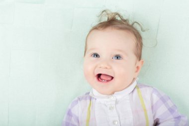 Beyaz güneşli yatak odasında sevimli bir bebek. Yeni doğmuş çocuk yatakta dinleniyor. Küçük çocuklar için çocuk odası. Çocuklar için tekstil ve yatak. Aile sabahı evde. Oyuncak ayıyla karnını doyururken doğan yeni çocuk..