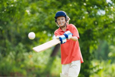 Kids playing cricket in summer park. Boy with bat and ball on cricket pitch. Helmet and guard for safe game. Sport for active child. Cricket club for school children. Sports activity and exercise. clipart