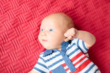 Beyaz güneşli yatak odasında örgü örülmüş, sevimli bir bebek. Yeni doğmuş çocuk yatakta dinleniyor. Küçük çocuklar için çocuk odası. Kış tekstil ürünleri ve çocuklar için yatak. Aile sabahı evde.. 
