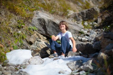Dağlarda yürüyüş yapan çocuklu bir aile. Küçük çocuklar güzel Alpler dağ manzarasında yürüyüş yaparlar. Bebekle seyahat et. Küçük bir çocukla gezmek ve kamp yapmak. Açık hava macerası.