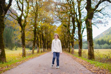 Dağlarda yürüyüş yapan çocuklu bir aile. Küçük çocuklar güzel Alpler dağ manzarasında yürüyüş yaparlar. Bebekle seyahat et. Küçük bir çocukla gezmek ve kamp yapmak. Açık hava macerası.
