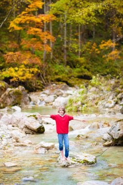 Dağlarda yürüyüş yapan çocuklu bir aile. Genç anne ve çocuklar güzel Alpler dağ manzarasında yürüyüş yapıyorlar. Bebekle seyahat et. Küçük bir çocukla gezmek ve kamp yapmak. Açık hava macerası.