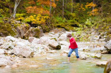 Dağlarda yürüyüş yapan çocuklu bir aile. Genç anne ve çocuklar güzel Alpler dağ manzarasında yürüyüş yapıyorlar. Bebekle seyahat et. Küçük bir çocukla gezmek ve kamp yapmak. Açık hava macerası.