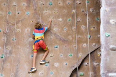 Çocuk kaya tırmanışı kursunda. Okullu çocuk kaya kırıyor. Çocuklar için aşırı spor. Çocuklar tırmanır. Sağlıklı açık hava aktivitesi. Aktif ve cesur genç.