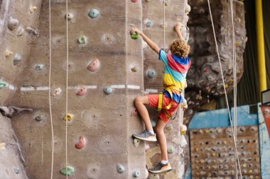 Çocuk kaya tırmanışı kursunda. Okullu çocuk kaya kırıyor. Çocuklar için aşırı spor. Çocuklar tırmanır. Sağlıklı açık hava aktivitesi. Aktif ve cesur genç.