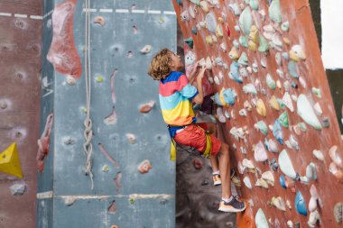 Çocuk kaya tırmanışı kursunda. Okullu çocuk kaya kırıyor. Çocuklar için aşırı spor. Çocuklar tırmanır. Sağlıklı açık hava aktivitesi. Aktif ve cesur genç.