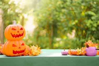 Cadılar Bayramı için aile dekorasyonu evi. Çocuklar için cadılar bayramı sanatı ve el sanatları. Şeker mi şaka mı dekorasyonu mu? Bahçe masasında fener ve balkabağı. Ürkütücü Cadılar Bayramı eğlencesi.
