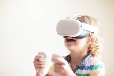 Sanal gerçeklik gözlüklü çocuk. Çocuklar için video kayıt seti. Küçük çocuk bilgisayar oyunu oynuyor. Modern dijital cihazla öğreniyorum. Çocuklar elektronik aletlerle ders çalışırlar. Gelecek eğitim konsepti. Eğlenceli oyun..