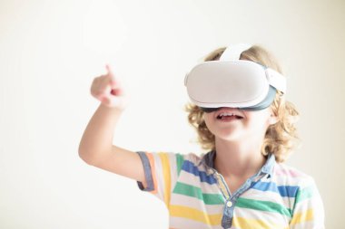 Sanal gerçeklik gözlüklü çocuk. Çocuklar için video kayıt seti. Küçük çocuk bilgisayar oyunu oynuyor. Modern dijital cihazla öğreniyorum. Çocuklar elektronik aletlerle ders çalışırlar. Gelecek eğitim konsepti. Eğlenceli oyun..