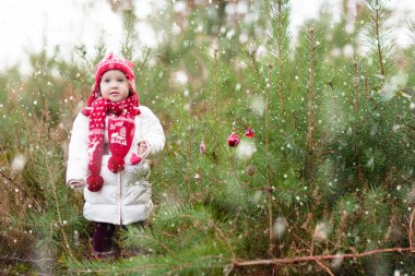 Noel Baba kostümlü bebek Noel ağacının altında. Hediye sepetindeki küçük çocukla eğlenceli mutlu noeller. Xmas hediyesi. Dışarıda karda oynayan bir çocuk. Kış parkındaki çocuk.
