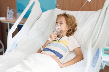 Hasta çocuk hastane odasında. Çocuk klinik koğuşunda. Oksijen tüplü ve hastane yatağında serum takılı küçük bir çocuk. Pediyatrist doktor hastayı muayene ediyor. Aile sağlığı ve sigortası. Çocuklar için ilaç.