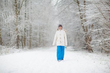 Çocuklar kış parkında karda oynarlar. Çocuklar karlı soğuk bir günde dışarıda oynuyorlar. Oğlan ve kız kızakla gezerken eğleniyorlar. Noel tatili aktivitesi. Kış havasında açık hava eğlencesi. Çocukla seyahat et..