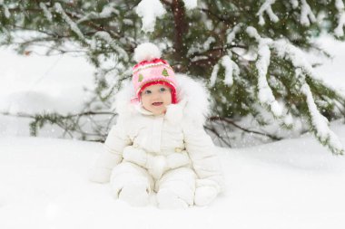 Çocuklar kış parkında karda oynarlar. Çocuklar karlı soğuk bir günde dışarıda oynuyorlar. Oğlan ve kız kızakla gezerken eğleniyorlar. Noel tatili aktivitesi. Kış havasında açık hava eğlencesi. Çocukla seyahat et..