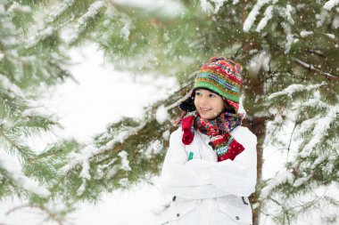Çocuklar kış parkında karda oynarlar. Çocuklar karlı soğuk bir günde dışarıda oynuyorlar. Oğlan ve kız kızakla gezerken eğleniyorlar. Noel tatili aktivitesi. Kış havasında açık hava eğlencesi. Çocukla seyahat et..