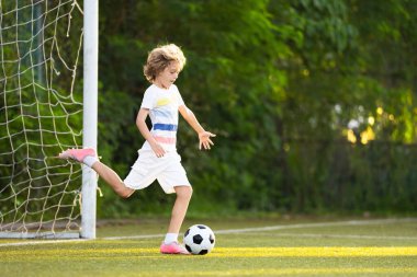 Çocuk futbol oynuyor. Çocuklar dışarıda futbol oynarlar. Küçük çocuk yaz parkında topa vuruyor. Küçük çocuklar için sağlıklı bir aktivite. Okul spor kulübü takımı. Futbol Küçükler Ligi.
