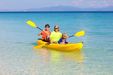 Çocuklar okyanusta kayak yapıyor. Tropikal denizde kanodaki çocuklar. Genç bir çocukla aktif tatil. Güzel bir sahilde kanoda küçük bir çocuk. Anaokulu çocuğuyla tatil aktivitesi. Aile suyu eğlencesi.