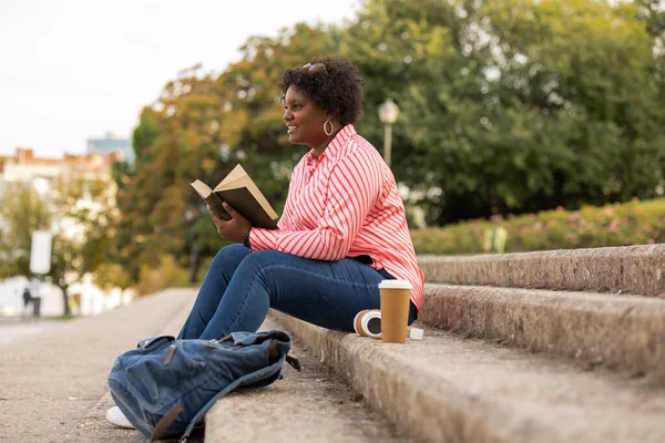 Пишна Африканка Сидить Сходах Відкритому Повітрі Читає Книгу — стокове фото