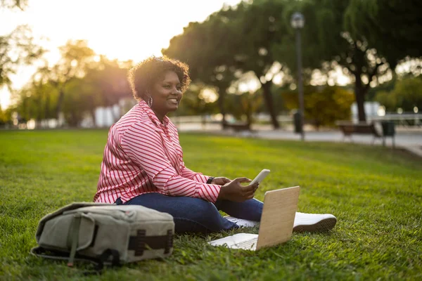 Feliz Mulher Afro Curvilínea Sentado Grama Com Laptop Telefone Móvel — Fotografia de Stock