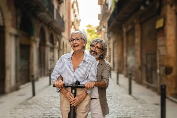 Happy Senior Couple Push Scooter Couple Riding Old Town — Stock Photo, Image