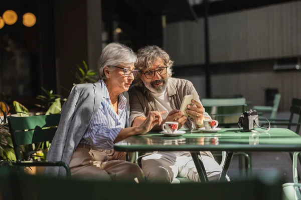 Casal Sênior Sentado Terraço Olhando Para Redes Sociais Smartphone Bebendo — Fotografia de Stock