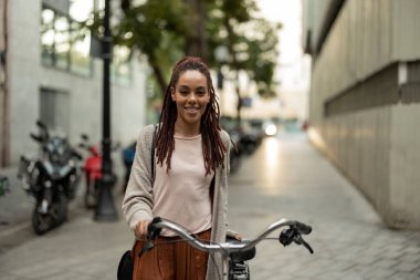 Şehirde bisiklet süren Afrikalı güzel bir Amerikalı kadının portresi.