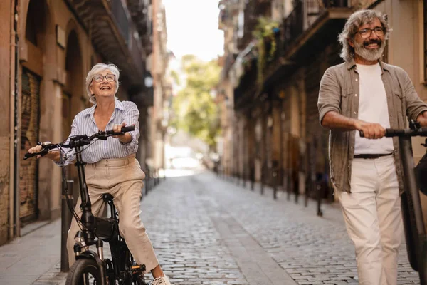 Happy Mature Gray Hair Couple Push Scooter Riding Old Town — Stock Photo, Image