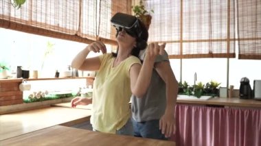 happy caucasian mature couple, in the kitchen, play in a virtual reality glasses, playing instrument on the simulator, funny adults