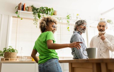 Ofisin mutfağındaki çok ırklı meslektaşlar kahve molası veriyorlar. Afro-Amerikan kadınına odaklan.