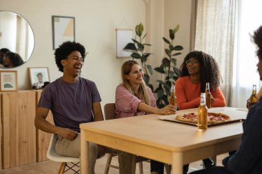 Evde pizza yiyip bira içen çok ırklı bir arkadaş grubu. Hint erkeğine odaklan..