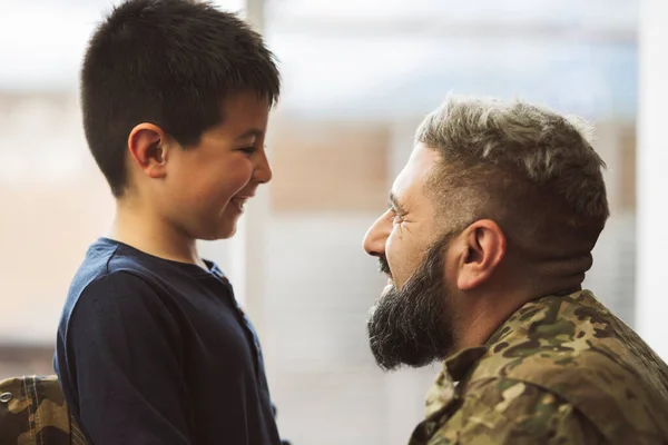 stock image Latin veteran soldier smiling with his son when returning from military service to home. Unconditional love concept. Focus on father face