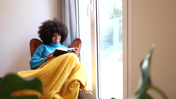 곱슬머리의 아프리카 미국인 창문에 담요로 소파에 — 비디오