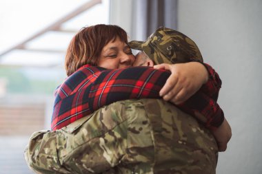 İspanyol gazi asker askerlikten eve dönerken karısına sarılıyor. Aşk ve aile kavramı. Latin olgun kadın yüzüne odaklan.
