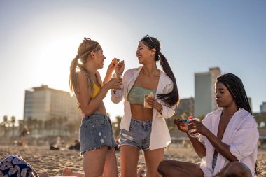 Happy female friends having fun and eating fresh pineapple fruit at boat party on the beach -Concept of youth, tropical, travel and summer vacation