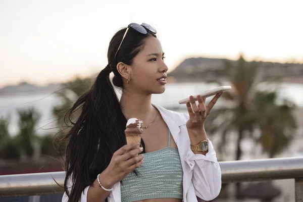asian woman with ice cream and mobile phone