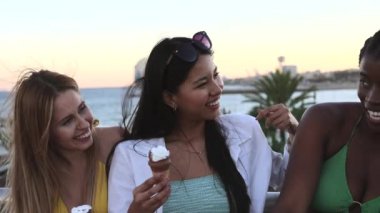 diverse friends eating ice cream near the beach on a summer day